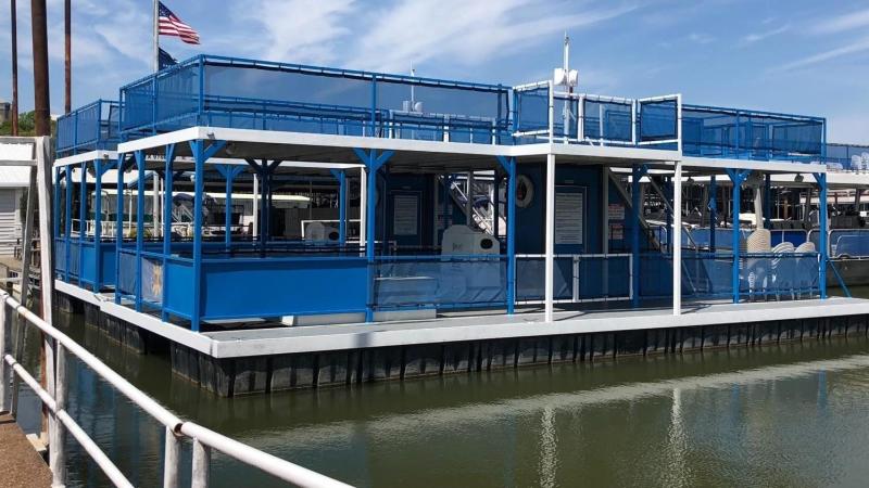 a blue boat docked next to a body of water