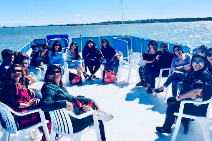 a group of people sitting next to a body of water