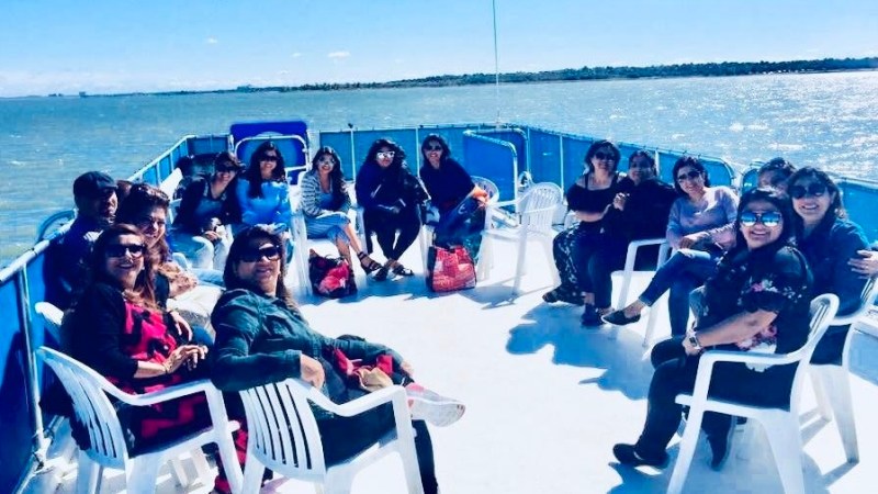 a group of people sitting next to a body of water