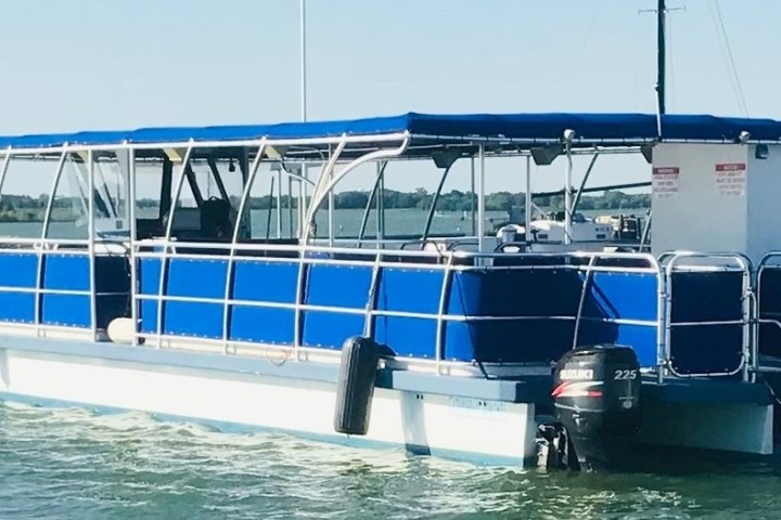 a blue and white boat sitting next to a body of water