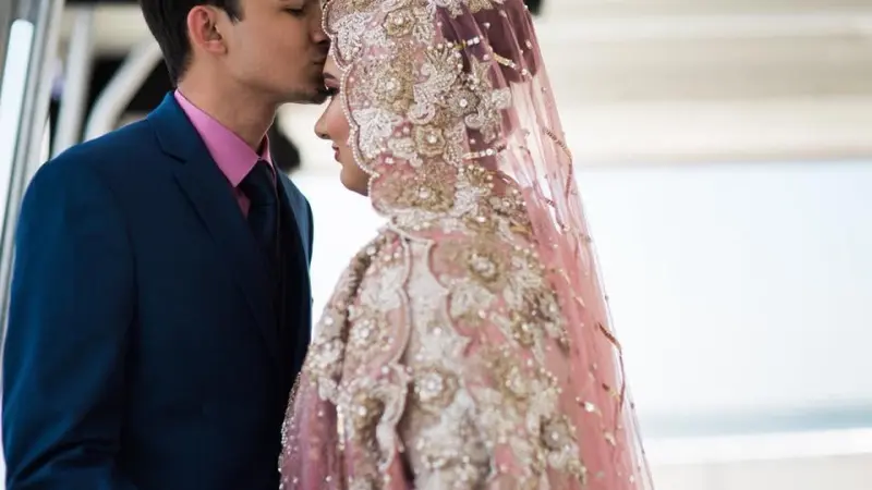 a person wearing a pink dress standing in front of a building
