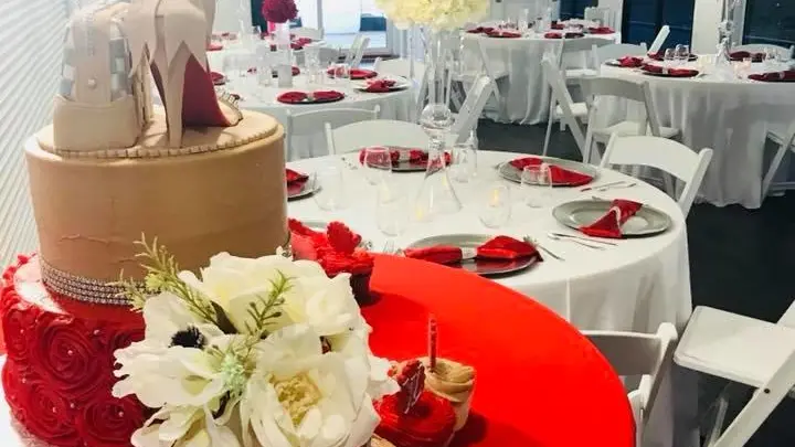 a group of people sitting at a red table with food