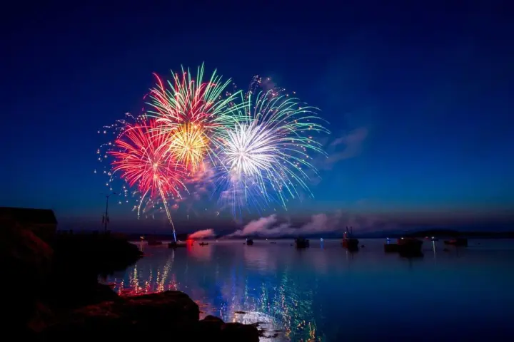 fireworks in the night sky over a body of water