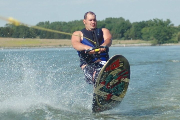 a man riding a wave on a surfboard jumping over a body of water