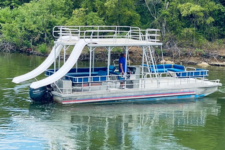 a boat floating along a river next to a body of water